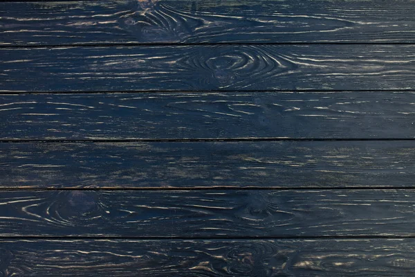 Mörk svart trästruktur bakgrunden sedda från ovan. Träplankor staplas vågrätt och har en sliten look. — Stockfoto