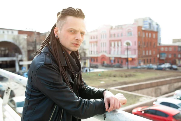 rocker rock star young man walking on the city street autumn day