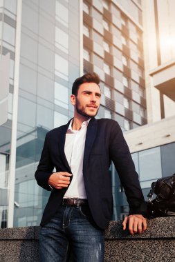 yakışıklı genç işadamı sakallı ve ofis binası yanında rahat şık deri çanta çerçevede sokakta duran iş kıyafeti.