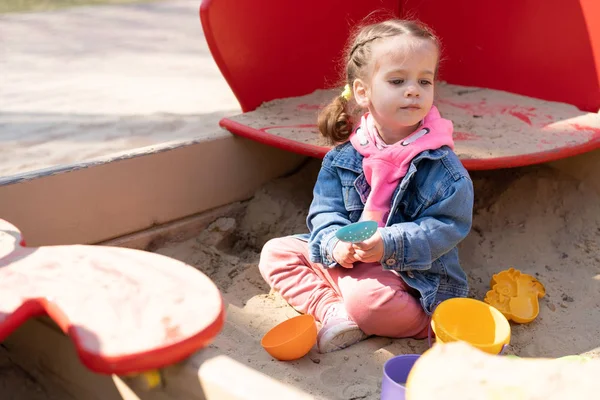 Симпатичная маленькая девочка на детской площадке, счастливый ребенок с удовольствием проводит время на свежем воздухе, счастливое детство — стоковое фото