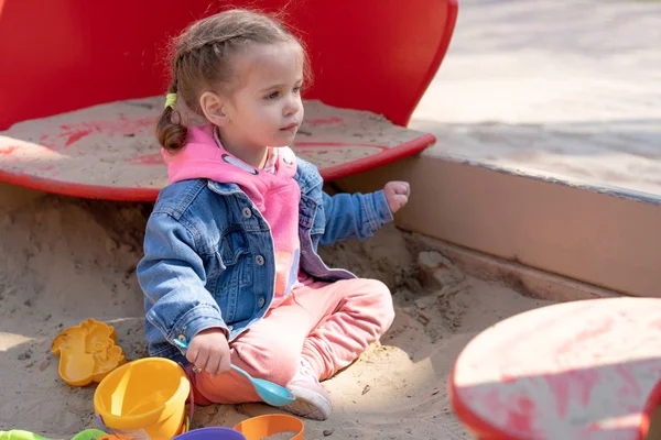 Niedliches kleines kaukasisches Mädchen auf dem Spielplatz, glückliches Kind, das gerne Zeit im Freien verbringt, glückliche unbeschwerte Kindheit — Stockfoto