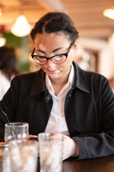 Vitiligo bir restoranda oturan Afrika kökenli güzel bir genç kız — Stok fotoğraf