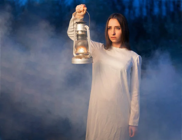 Misteriosa ragazza mistica in una oscura foresta notturna con una lampada al cherosene in mano — Foto Stock