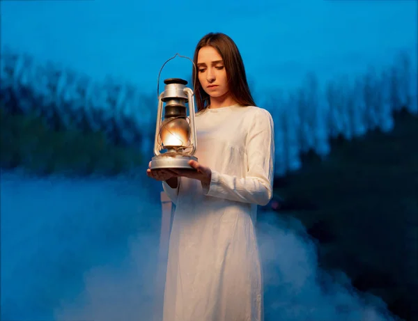 彼女の手に灯油ランプを持つ暗い夜の森の神秘的な神秘的な女の子 — ストック写真
