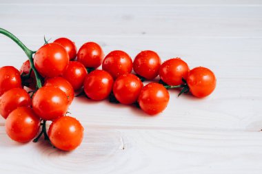 Beyaz ahşap masada kiraz domates