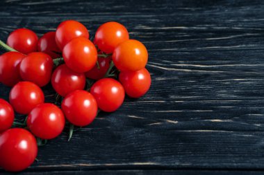 Koyu siyah ahşap masada Kiraz domates