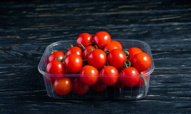 Ahşap masaüzerinde plastik kutuiçinde Kiraz domates