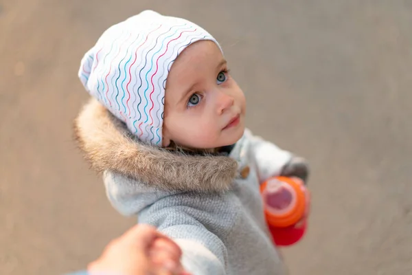 Een meisje loopt in het Park houden van de hand van haar moeder. — Stockfoto