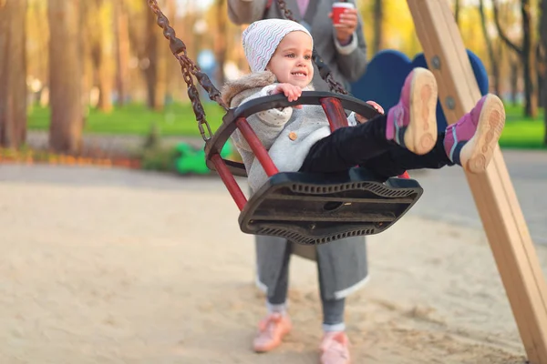 Glückliches Kind Mädchen auf Schaukel im Sonnenuntergang Herbst. Kleines Kind spielt im Herbst im Naturpark — Stockfoto