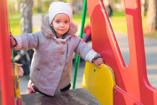 Kleines süßes Mädchen spielt im Herbst auf dem Spielplatz — Stockfoto