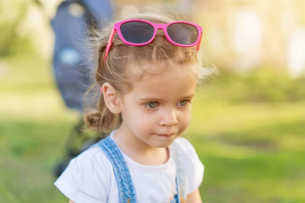 Weinig Kaukasische meisje met zonnebril op haar hoofd wandelingen op de natuur — Stockfoto
