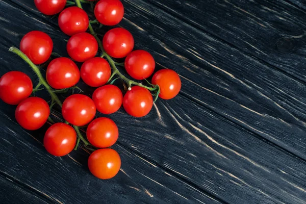 Черри помидоры на темно-черном деревянном столе — стоковое фото