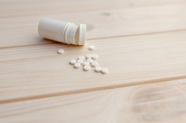 Hapları ve pill şişe beyaz ahşap zemin üzerinde