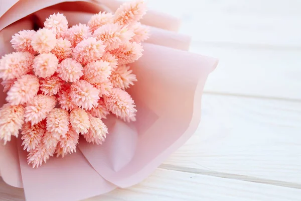 Mooi boeket van droge roze bloemen op een houten witte achtergrond. Minimalisme, ruimte voor tekst. Gift Card — Stockfoto