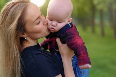Güzel genç anne bir yaz par onun küçük oğlu ile yürüyor