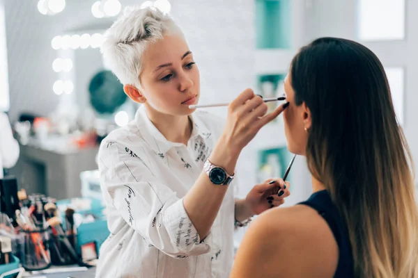 Parlak temel rengi göz farı modelinin e üzerinde uygulama makyaj sanatçısı