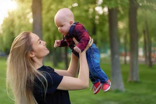 Beautiful young mother walks with her little son in a summer par — Stock Photo, Image