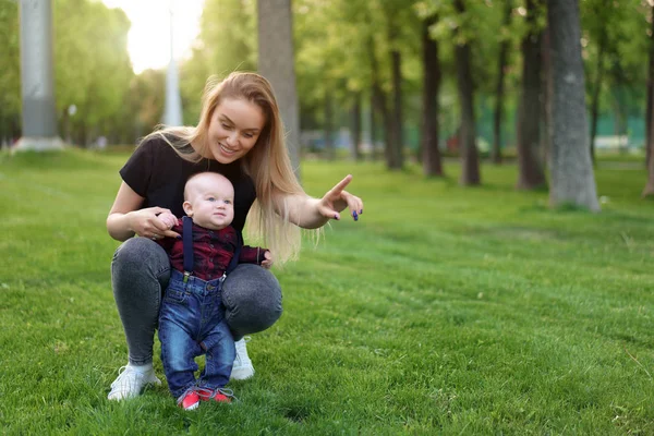 Beautiful young mother walks with her little son in a summer par — Stock Photo, Image