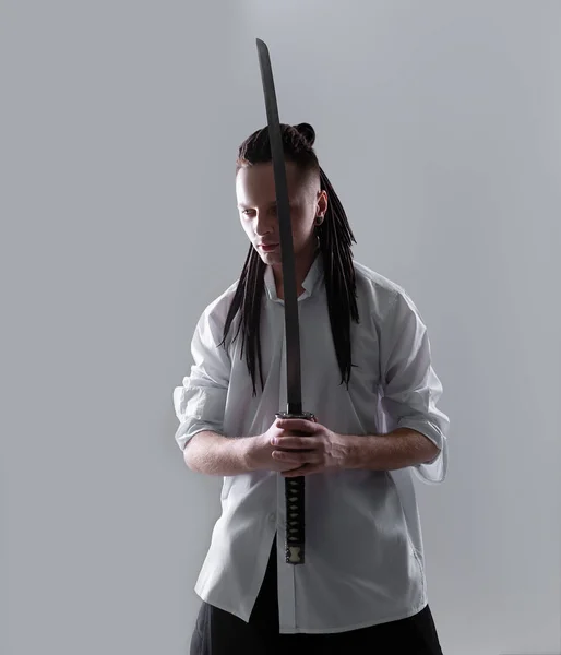 Νεαρός άνδρας που κρατάει ένα σπαθί σαμουράι. Φωτογραφία αίγλη. — Φωτογραφία Αρχείου