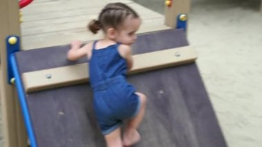 Oyun parkında küçük bir kız. Yaz aylarında dışarıda oynayan bir çocuk. Mutlu çocukluk.