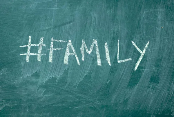 Family hashtag it handwritten with white chalk on a green blackboar — Stock Photo, Image