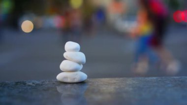 Şehir koşuşturma ve trafik arka planda sakin ve meditasyon Kavramı Sembolü. Piramit şeklinde taş deniz çakıl taşları