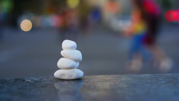 Concept Symbole de calme et de méditation sur fond d'agitation urbaine et de circulation. Pierres galets de mer sous la forme d'une pyramide — Video