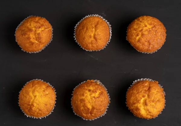 Auf einer Tischplatte stehen appetitliche Muffins. traditionelles Gebäck auf dunklem Hintergrund Minimalismus. — Stockfoto