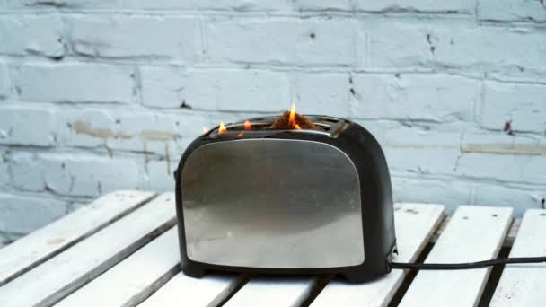 燃えるトースタートーストの2つのスライスが白い背景の上に火に引っ掛かったトースター — ストック動画