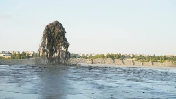 Duża fontanna wody miesza się z piaskiem, który bije z metalowej rury na błękitne niebo. Wydobycie piasku. — Wideo stockowe