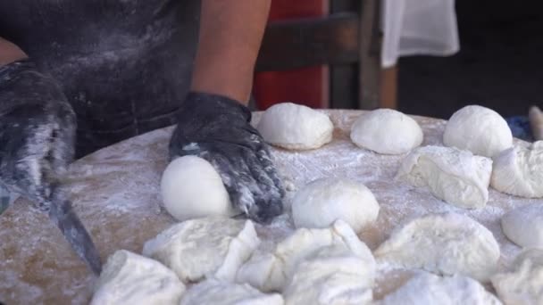 Chef fekete kesztyű darabok nyers tésztát darabokra, hogy pizza pogácsákat kenyér. — Stock videók