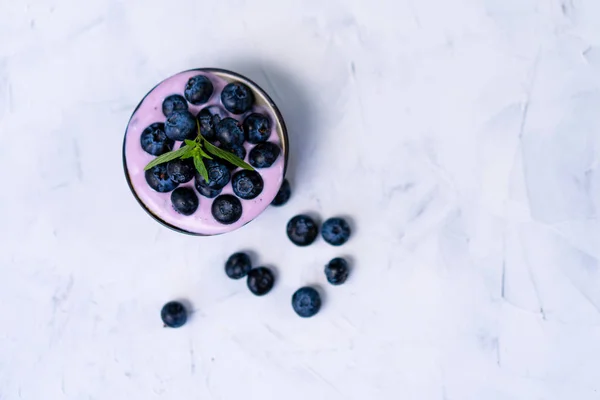 美味的新鲜蓝莓酸奶摇甜甜品在陶瓷碗站在白色表背景. — 图库照片