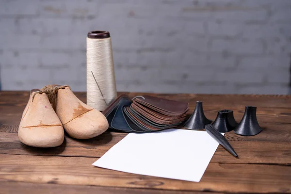 ダークウッドテーブルの上で最後に靴や木製の靴のための革サンプル. — ストック写真