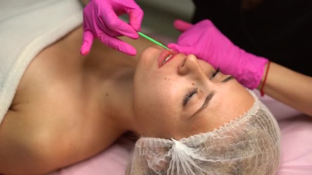 Doctor cosmetologist does procedure permanent makeup female client lips 4K — Stock Video