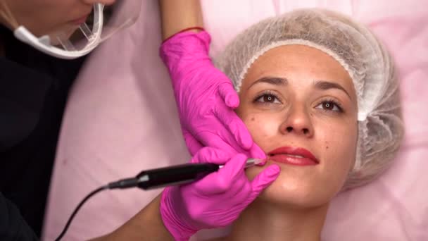 Arts cosmetoloog doet procedure permanente make-up vrouwelijke cliënt lippen 4k — Stockvideo