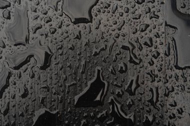 Siyah yüzeye yağmur damlaları