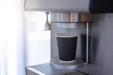 Kağıt bardaklı kahve makinesi ve solda boş yer. Mesaj için..