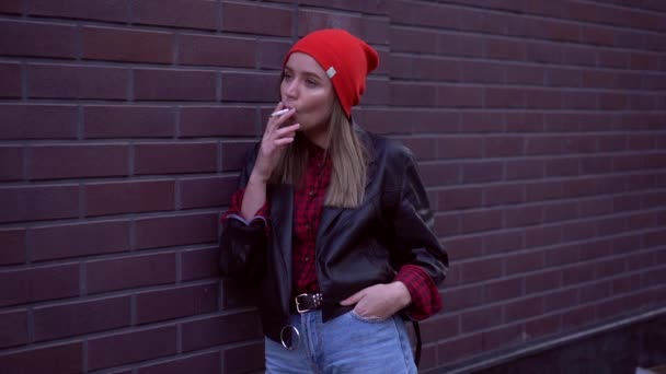 Young Mooi stijlvol Europees meisje dat op de achtertuin staat bij het bouwen en roken van een sigaret. Stress. Slechte gewoonte, ongezonde levensstijl. — Stockvideo