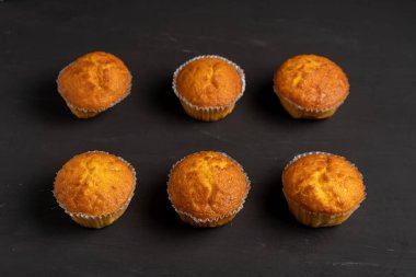Iştah açıcı muffins bir masa üstü görünümünde duruyor. Koyu bir arka plan minimalizm geleneksel hamur işleri.