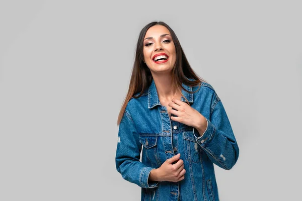 Beautiful caucasian girl in a denim jacket posing in the studio on a white background. — Stock Photo, Image