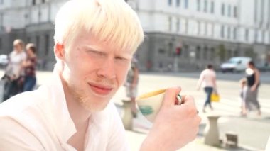 açık havada duran bir albino adam portresi 