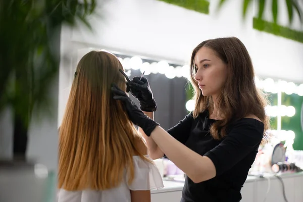 Молода косметологка біла дівчина тримає модель корекції брів — стокове фото