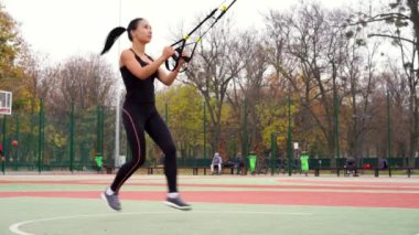 Ukrayna Kharkov Ekim 2019 Güzel atletik bayan antrenör TRX sistemi ile alıştırmalar yapıyor