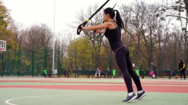 Ukrayna Kharkov Ekim 2019 Güzel atletik bayan antrenör TRX sistemi ile alıştırmalar yapıyor