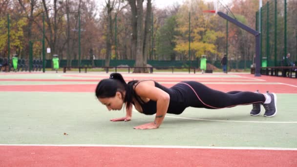 Ukrajina. Charkov říjen 2019 Běžec fit žena zahřívá před sportovním tréninkem na hřišti. Real time video běžec fit dívka strečink před sportovním tréninkem v parku — Stock video