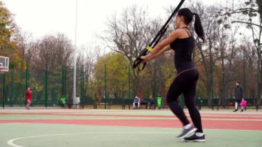 Ukrayna Kharkov Ekim 2019 Güzel atletik bayan antrenör TRX sistemi ile alıştırmalar yapıyor
