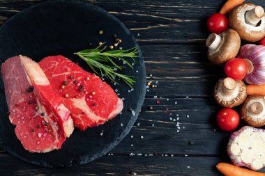 Masanın bir tarafında güzel sulu, çiğ sığır eti diğer tarafında sebze vardır. Yemeğini seç. Sağlıklı beslenme konsepti