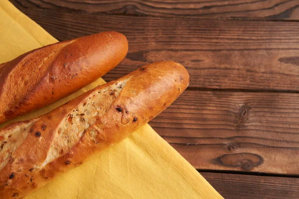 Duas Baguetes Francesas Crocantes Mentira Pano Amarelo Guardanapo Mesa Madeira — Fotografia de Stock