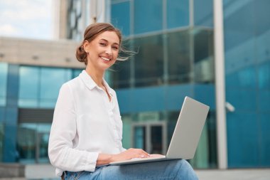 İş kadını başarılı kadın iş adamı dışarıda şirket binası dışında dizüstü bilgisayarı olan hoş beyaz iş kadını orta yaşlı iş kadını online bankacılık