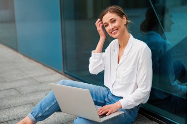 İş kadını dizüstü bilgisayarı başarılı kadın iş adamı dışarıda şirket binası dış mimarisi dalgın beyaz iş kadını orta yaş ekom anlaşması Online bankacılık